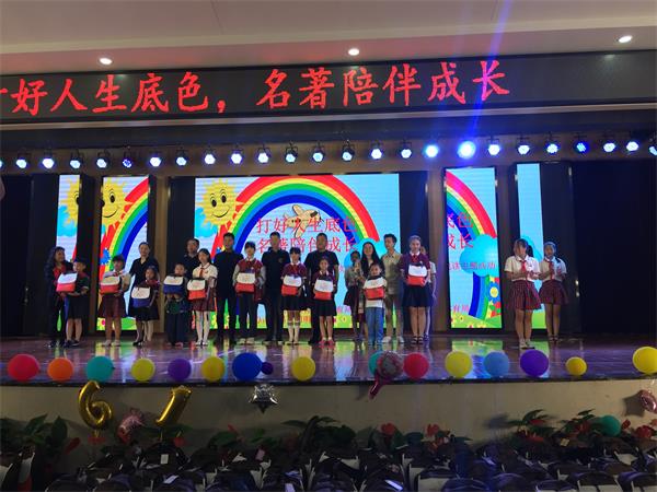 1559636773280069273.jpg 受捐学生代表上台领取名著小书包.jpg